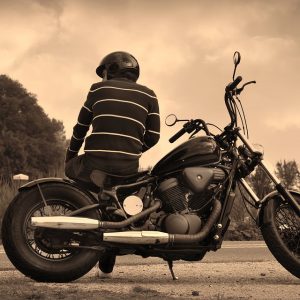 Guy sitting on parked motorcycle