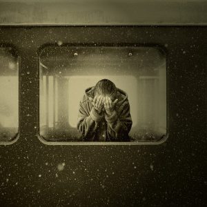 A person sits in a train and mourns