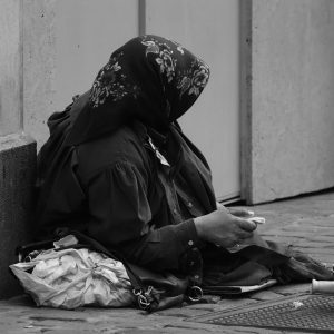 A beggar is sitting on the street