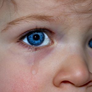 The blue-eyed child is crying