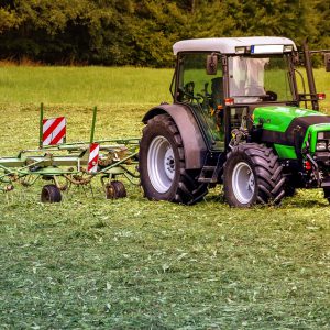 Tractor in the field with auxiliary attachment